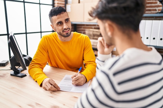 Two man ecommerce business workers writing on document at office