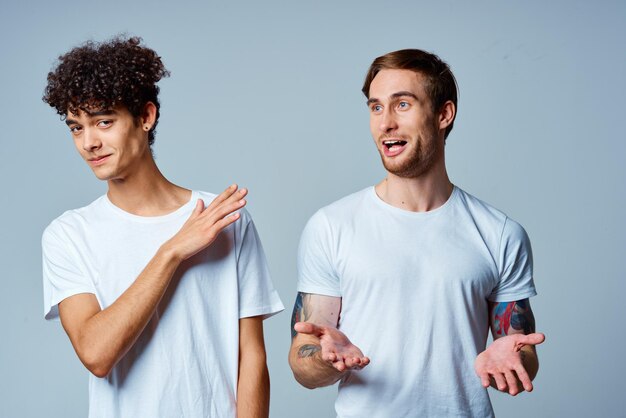 Фото Два человека в белых футболках стоят рядом с эмоциями дружбы высококачественной фотографии