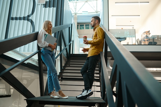 Two managers talks on stairs in IT office