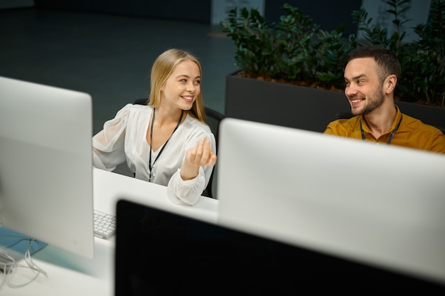 Two managers works on computers in IT office