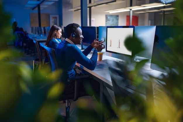 Due manager lavorano nell'ufficio notturno, vista posteriore