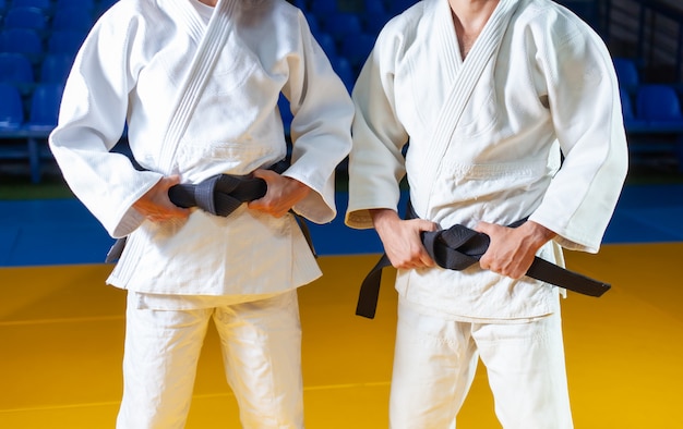 Photo two masters of sports in judo in a white kimano with a black belt. crop photo