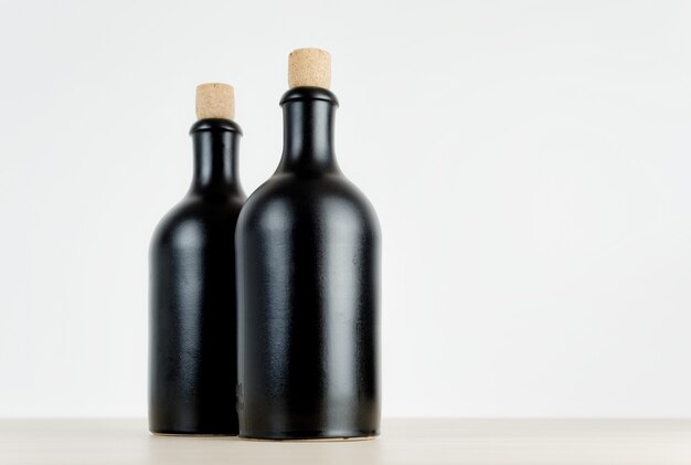 Two matte black empty bottles on a table