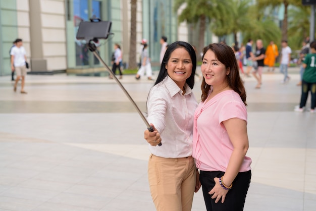 Due donne asiatiche mature insieme fuori dal centro commerciale nella città di bangkok