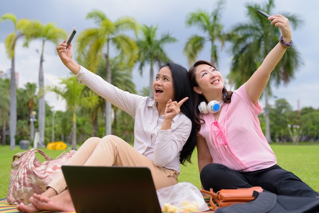 Two mature Asian women together relaxing at the park