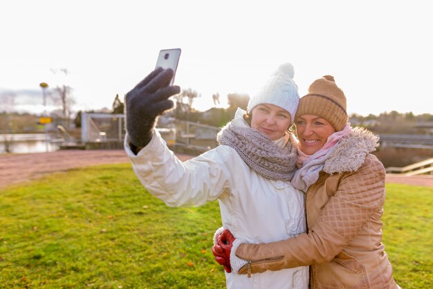 Two mature beautiful women together against scenic view of nature