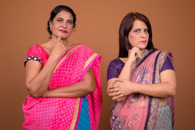 two mature Indian women wearing Sari Indian traditional clothes together 