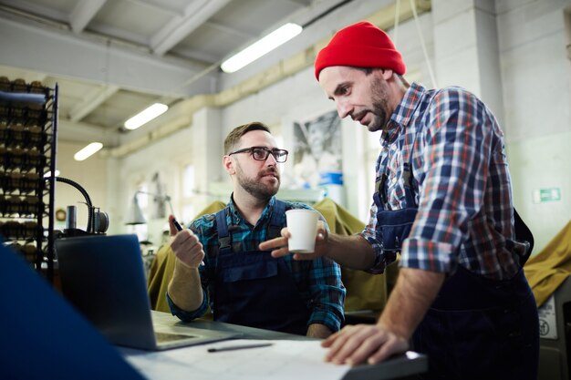 Two Mature Men Working at Factory