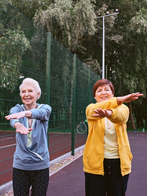 写真 公園の健康的なライフスタイルの概念でスポーツ運動をしている2人の成熟した女性