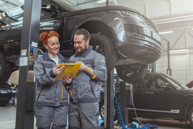 Two mechanics repairing a car