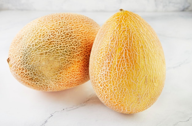 Two melons on light marble in home kitchen