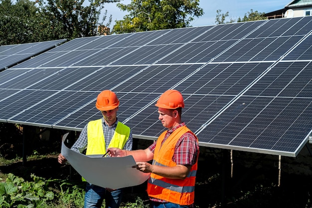 Two men against solar panels making agreement about installation of station