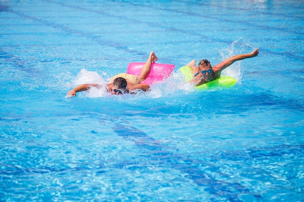 Two men bathe in the pool and relax