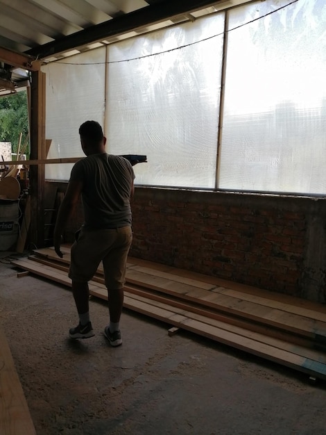 Two men carrying a wooden board working in a carpentry shop