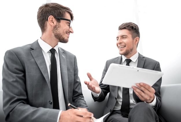 Two men chatting while sitting in the office