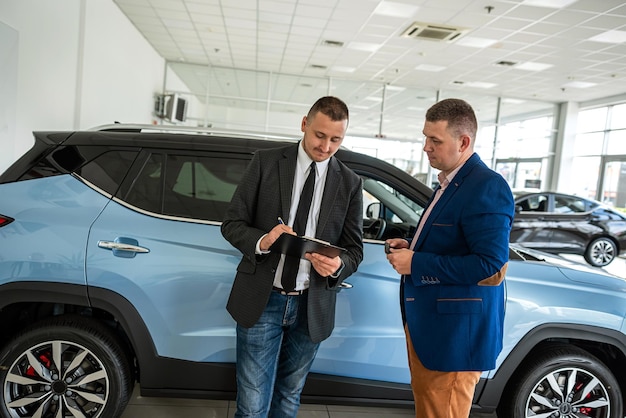 Two men discuss the details of a purchase at car dealership