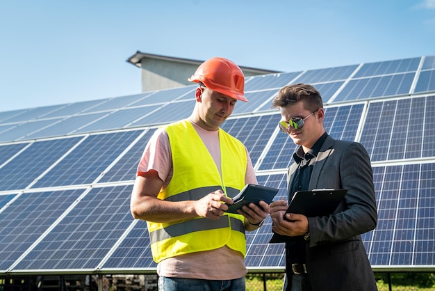 Two men discussing installation plan of new solar station Green energy concept renewable energy