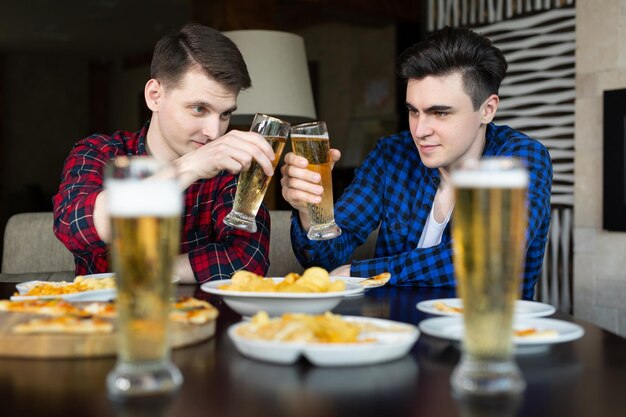 Foto due uomini bevono birra in un pub