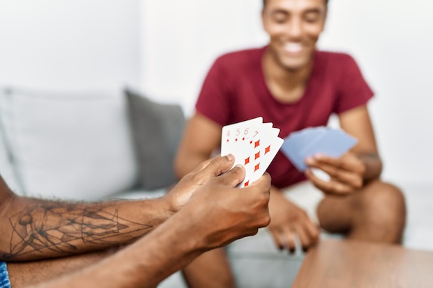 Foto due uomini amici che giocano a carte da poker seduti sul divano di casa