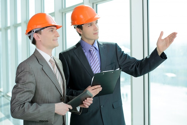 Two men in hard hats at construction site.