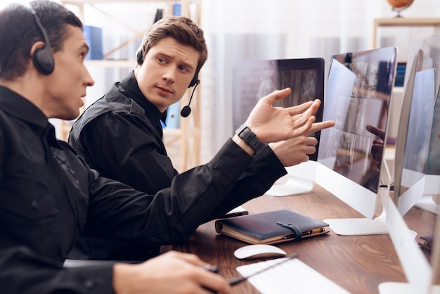 Two men in headphones are on their heads.