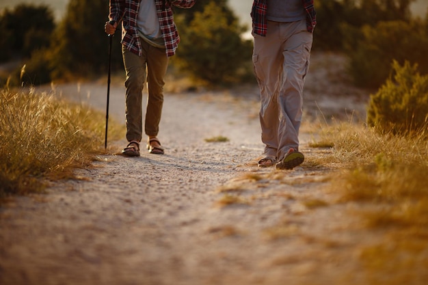 Two men hikers enjoy a walk in nature sunset time in summer