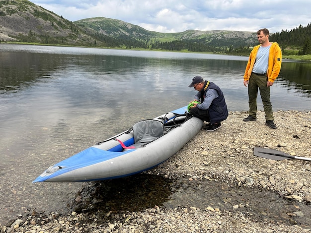 Due uomini in kayak sul lago di montagna. stile di vita sportivo di nuoto attivo.