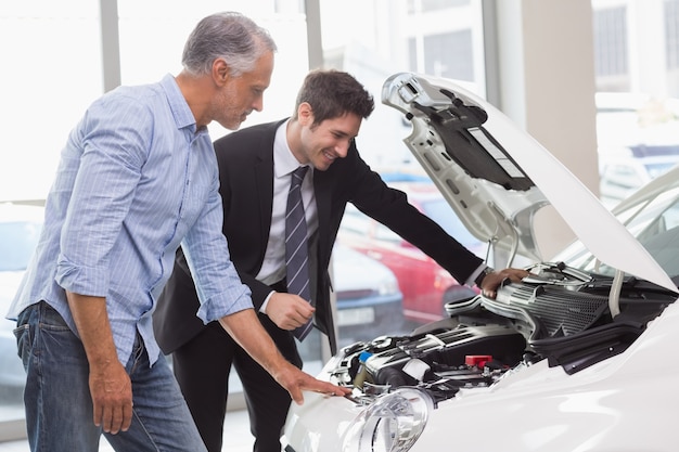 Two men looking at a car engine