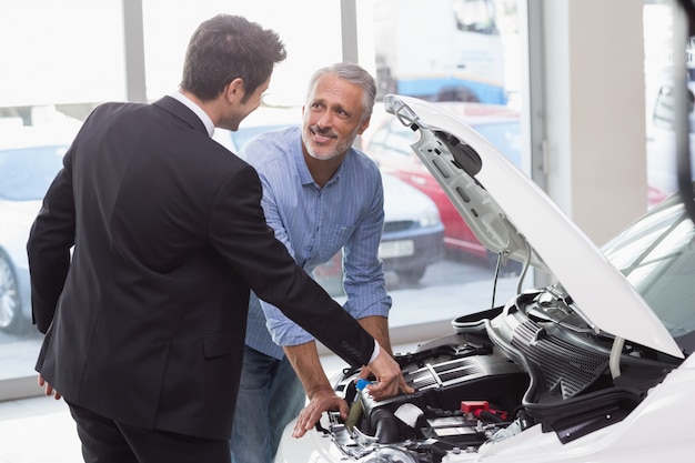 Two men looking at a car engine