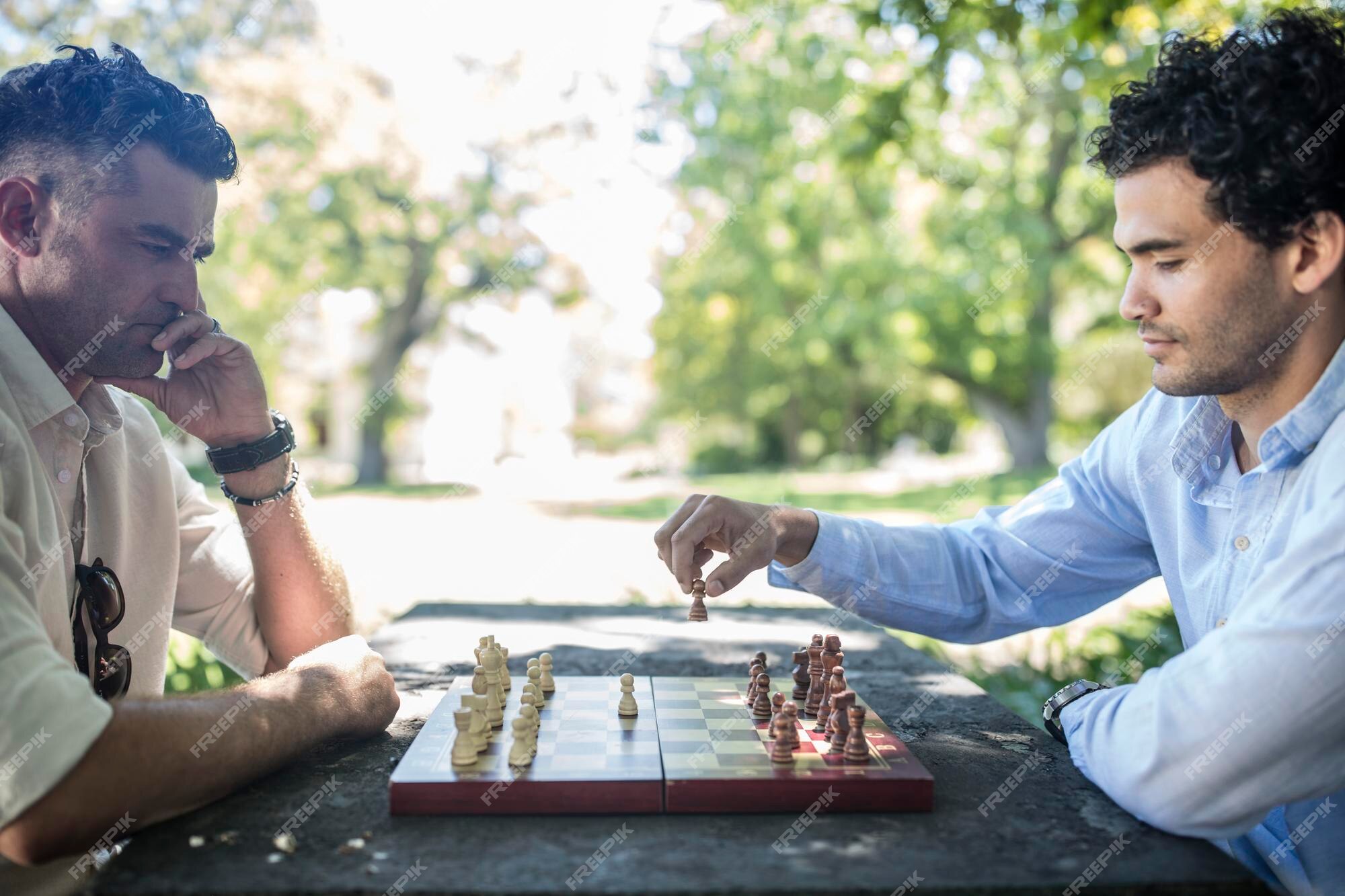 Premium Photo  Two young man are playing chess