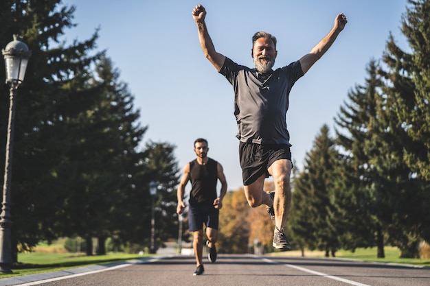 The two men running on the road in the park