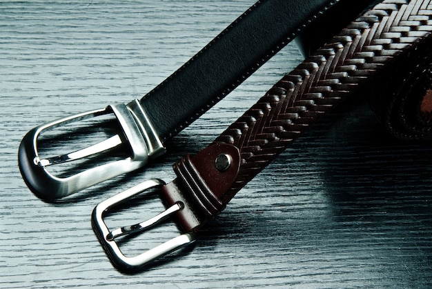 Two men\'s belts on grey background