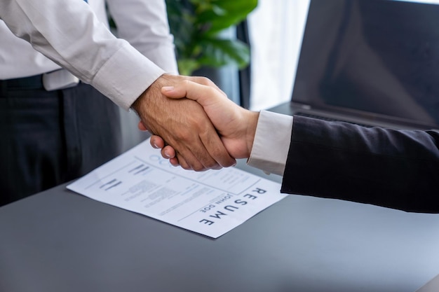 Two men shaking hands over a document that says'business'on it