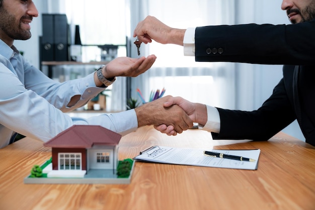 Two men shaking hands over a house and a document