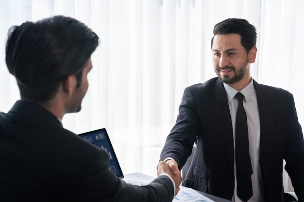 Two men shaking hands, one of which is the number 1.