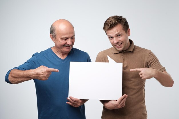 Foto due uomini che mostrano copyspace vuoto per l'annuncio