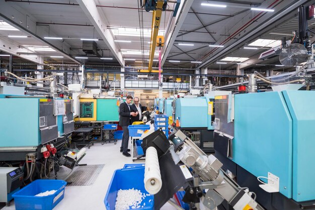 Foto due uomini che parlano nell'officina della fabbrica