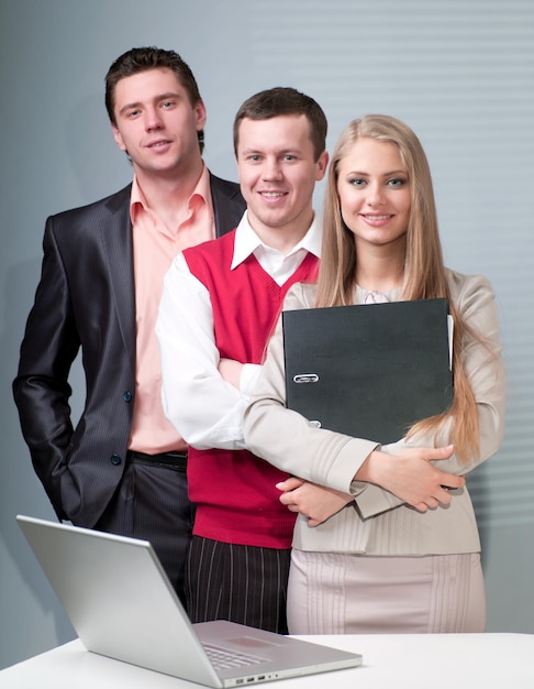 Two men and woman working with a computer in the office