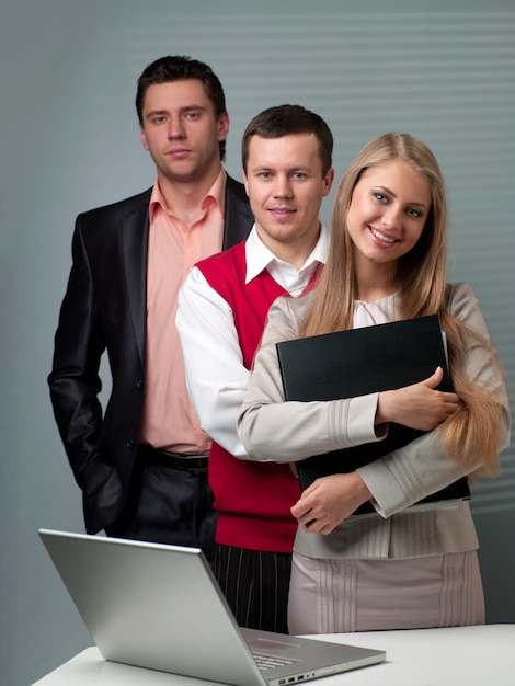 Two men and woman working with a computer in the office