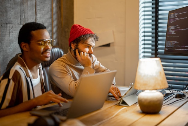 Two men working on computer at home office