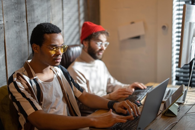 Two men working on computer at home office