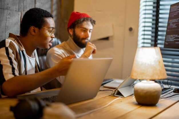 Two men working on computer at home office