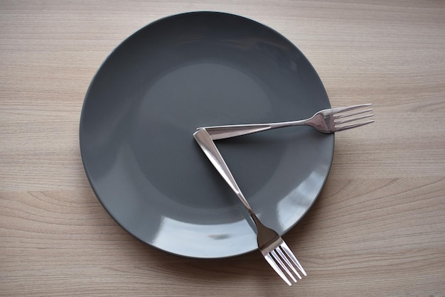 Photo two metal forks on a gray plate