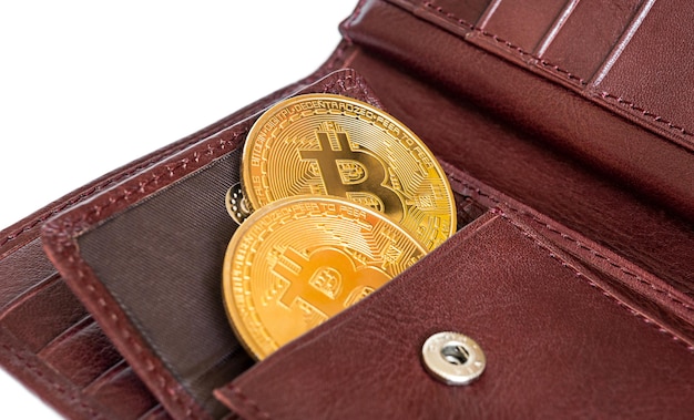 Due bitcoin dorati in metallo in un portafoglio marrone.