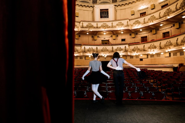 Two mime artist bowing in an empty auditorium