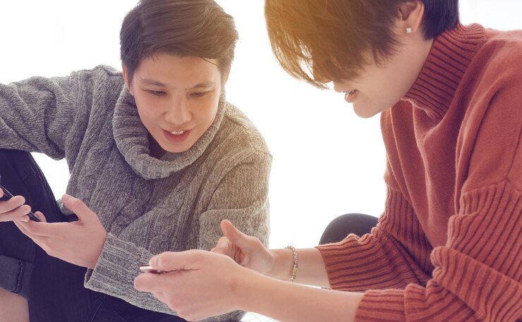 Photo 2人のアジア系混血の友人がソーシャルメディアからの情報とニュースを交換する