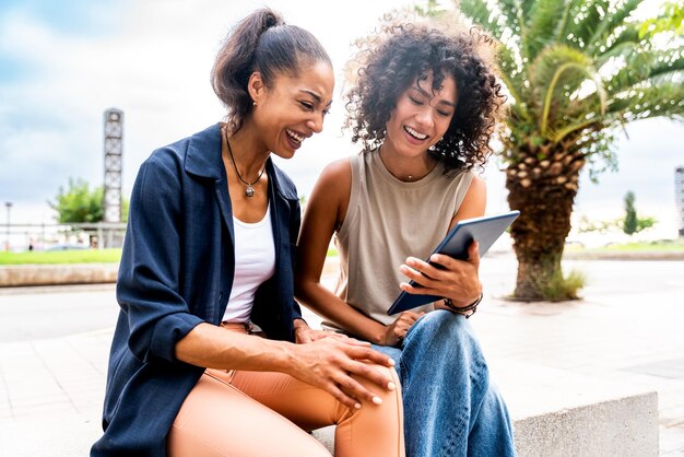 Two mixed race hispanic women bonding outdoors