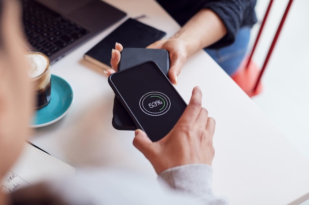 Photo two mobiles phone to phone wirelessly charging on desk