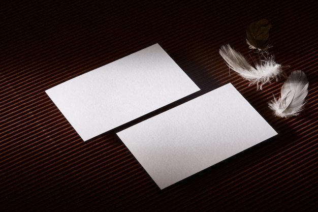 two mockup business card on a brown surface