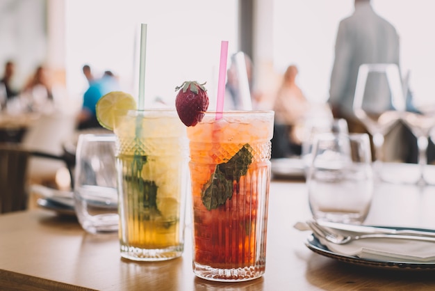 Two mojito cocktails made with aged rum mint and different fruits